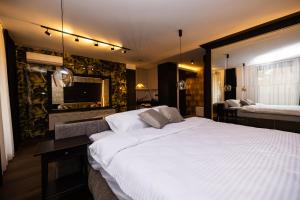 a bedroom with a large white bed and a television at Kron in Novi Sad