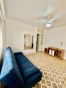 un soggiorno con un divano blu e un tavolo di Apto 1 Dormi para até 6 pessoas a Capão da Canoa