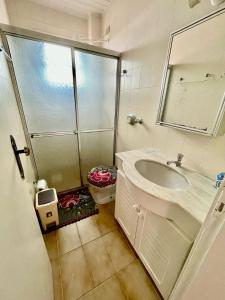 un bagno con doccia, lavandino e specchio di Apto 1 Dormi para até 6 pessoas a Capão da Canoa
