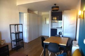 a kitchen and dining room with a table and chairs at Appartement Pont Royal vu lac in Mallemort