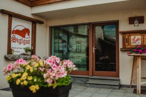Una tienda con una puerta con flores delante. en Reiterhof Siglgut, en Tarres 28 fotos más