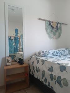 a bedroom with a bed and a table with a mirror at Sol guest house in Pipa