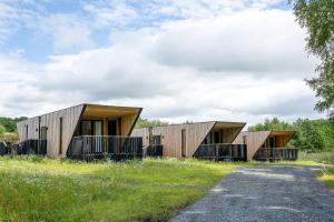 a house with wooden cladding in a field at Landal Barnsoul in Shawhead +10 photos