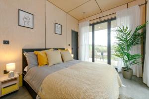 a bedroom with a bed and a large window at Landal Barnsoul in Shawhead