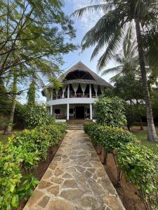 Villa Peponi Royale Watamu في واتامو: مبنى أبيض كبير مع مسار يؤدي إليه