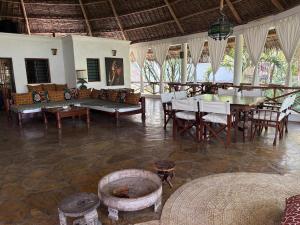 a living room with a table and chairs and a couch at Kitu Sawa Sawa in Watamu