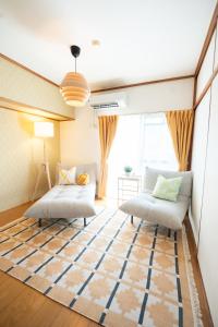 a living room with two beds and a rug at 海が見える隠れ家 -Tsukushi瀬戸内- in Takamatsu