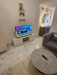 a living room with a tv and a couch and a table at الريامي 4 in Sharjah