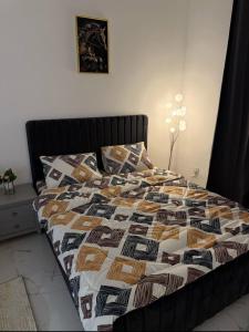 a bed with a comforter and pillows in a bedroom at الريامي 4 in Sharjah +2 photos