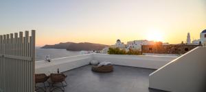 a balcony with chairs and a view of the ocean at Oia Treasures Art Suites in Oia