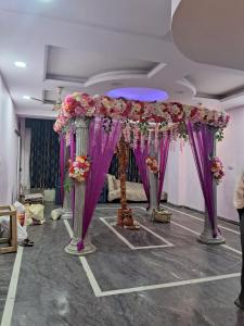 une pièce avec un bouquet de fleurs violettes et roses dans l'établissement Hotel Shri Laxmi Palace, à Kanpur