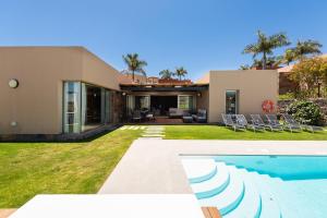 een villa met een zwembad en een huis bij Premium House with Private Heated Pool and Bbq in La Playa de Arguineguín