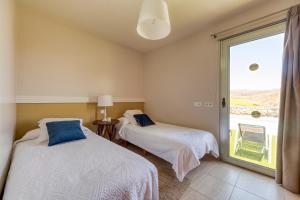 twee bedden in een kamer met een groot raam bij Premium House with Private Heated Pool and Bbq in La Playa de Arguineguín +22 foto's