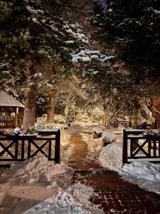 two picnic tables covered in snow in a park at Hotel Pod Jeleniem in Świeradów-Zdrój