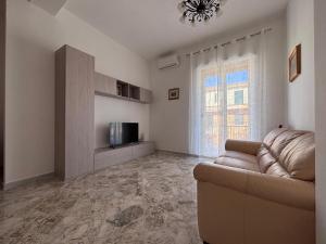 un soggiorno con un divano e una televisione di Salerno a due passi dal mare a Salerno