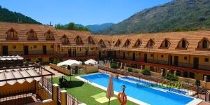 a hotel with a swimming pool in front of a mountain at NUEVO OCTUBRE 2025 Dúplex Sierra de Cazorla II in Arroyo Frio