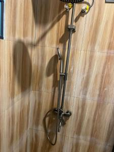 einen Duschkopf im Bad mit Holzboden in der Unterkunft pojok kahyangan homestay and cabin in Kejajar