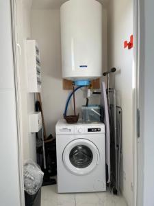 eine Waschmaschine und Trockner in einem kleinen Zimmer mit in der Unterkunft Gîte de la loge SAMY in Châtillon-sur-Broué