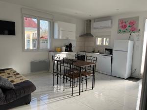 eine Küche mit Tisch und Stühlen in einem Zimmer in der Unterkunft Gîte de la loge SAMY in Châtillon-sur-Broué