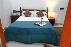 a bedroom with a bed with a blue and white bedspread at Entire Vintage Apartment, Historic Heights Haven in Noida