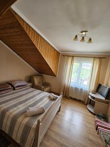 Un dormitorio con una cama grande y una ventana. en Zirka Karpat, en Yasinya