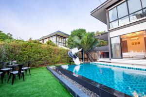 a swimming pool in the backyard of a house at Emery Pool Villa Pattaya in Ban Huai Yai