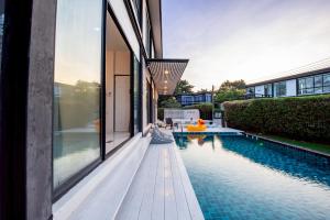 an external view of a house with a swimming pool at Emery Pool Villa Pattaya in Ban Huai Yai