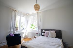 1 dormitorio con 1 cama y 1 silla frente a una ventana en Gästezimmer Volksdorf, en Hamburgo