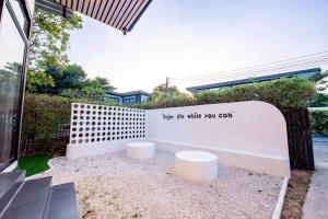 ein weißer Zaun mit einem Schild, auf dem steht: Genieße es, solange du kannst in der Unterkunft Emery Pool Villa Pattaya in Ban Huai Yai