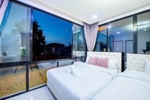 zwei Betten in einem Zimmer mit großen Fenstern in der Unterkunft Emery Pool Villa Pattaya in Ban Huai Yai + 38 Fotos