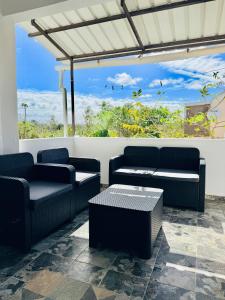 a patio with couches and tables and a view of the ocean at Devika villa in Triolet
