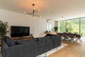 a living room with a large couch and a television at Elysium São Vicente - Designer Villa with Ocean View, Heated Pool, Jacuzzi & Sauna in São Vicente