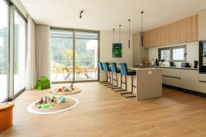 a kitchen with blue chairs and a kitchen counter at Elysium São Vicente - Designer Villa with Ocean View, Heated Pool, Jacuzzi & Sauna in São Vicente