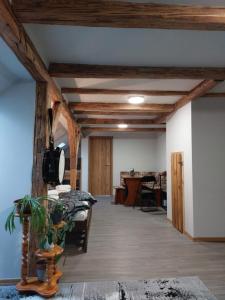 ein Wohnzimmer mit Holzdecken und einem Tisch in der Unterkunft Apartmány Arin in Jáchymov