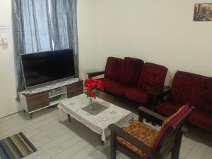 a living room with a couch and a tv at D' Farm Homestay in Sipitang
