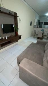 een woonkamer met een bank en een flatscreen-tv bij Casa Cariri Mobiliada com 2 Quartos e 2 Camas in Juazeiro do Norte