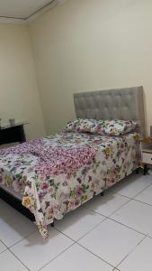een slaapkamer met een bed met een bloemdekbed bij Casa Cariri Mobiliada com 2 Quartos e 2 Camas in Juazeiro do Norte +19 foto's