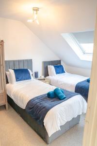a bedroom with two beds with blue pillows at Spacious 4 Bed 2 Bath House in Beoley