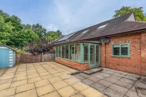 a brick house with a patio in front of it at Spacious 4 Bed 2 Bath House in Beoley