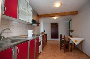 a kitchen with red cabinets and a table and a tableablish at Apartment Tomic A-5 in Lovran