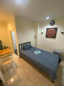 a bedroom with a blue bed and a table at Relax home massage Ao nang 1 in Ao Nang 