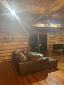 a living room with a couch in a log cabin at Chalet canadien en Morvan in Rouvray +10 photos