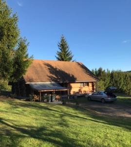 una casa con un coche aparcado delante en Chalet canadien en Morvan, en Rouvray