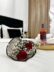 Una botella de vino y flores en una cama. en Panthera-urban-studio, en Xanthi 7 fotos más