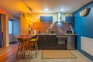 a kitchen with a stove and a counter with stools at Twilight Star Spa - Sauna & Private Cinema - Free Parking in Amiens +6 photos