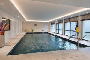 una piscina in una stanza con finestre e una piscina interna di DOMITYS - Galia a Brive-la-Gaillarde