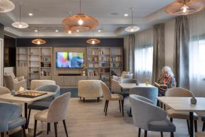 una sala d'attesa vuota con tavoli e sedie di DOMITYS - Galia a Brive-la-Gaillarde