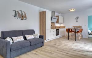 a living room with a couch and a kitchen at Gite Gouville Sur Mer in Gouville-sur-Mer
