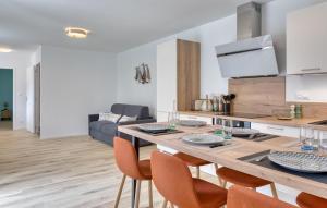 a kitchen and living room with a dining table and chairs at Gite Gouville Sur Mer in Gouville-sur-Mer