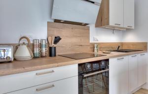 a kitchen with white cabinets and a counter top at Gite Gouville Sur Mer in Gouville-sur-Mer